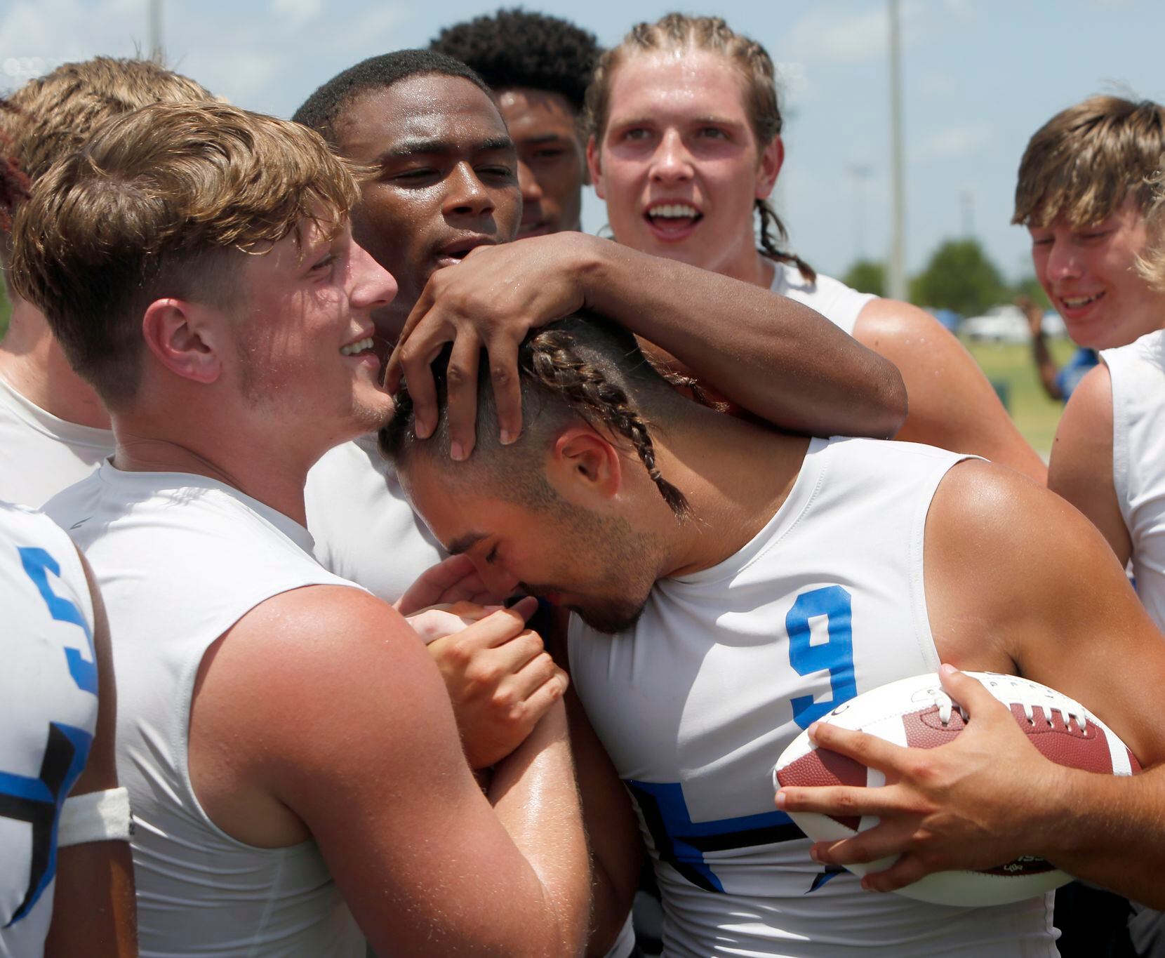 Hebron players surround and congratulate Hawks quarterback Jacob Buniff (9) after he accepted the championship football following their Division 1 championship victory over Lake Travis, 28-26.The state 7 on 7 football tournament attracted athletes from schools throughout the state. The competition brackets for the final day of competition was held at Veterans Park in College Station on June 25, 2021. (Steve Hamm/ Special Contributor)