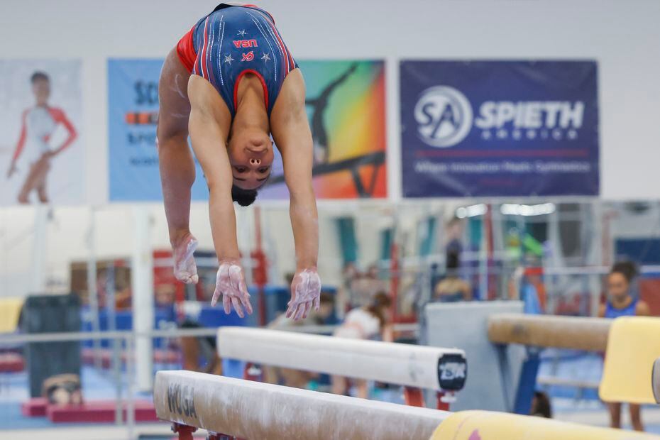 Gymnast Konnor McClain, 17, practices an arch on the balance beam during her regular...