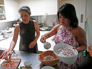 Tina Danze (left) and Chonnie Richey prepare food for a potluck at Tina Danze's home in Dallas.