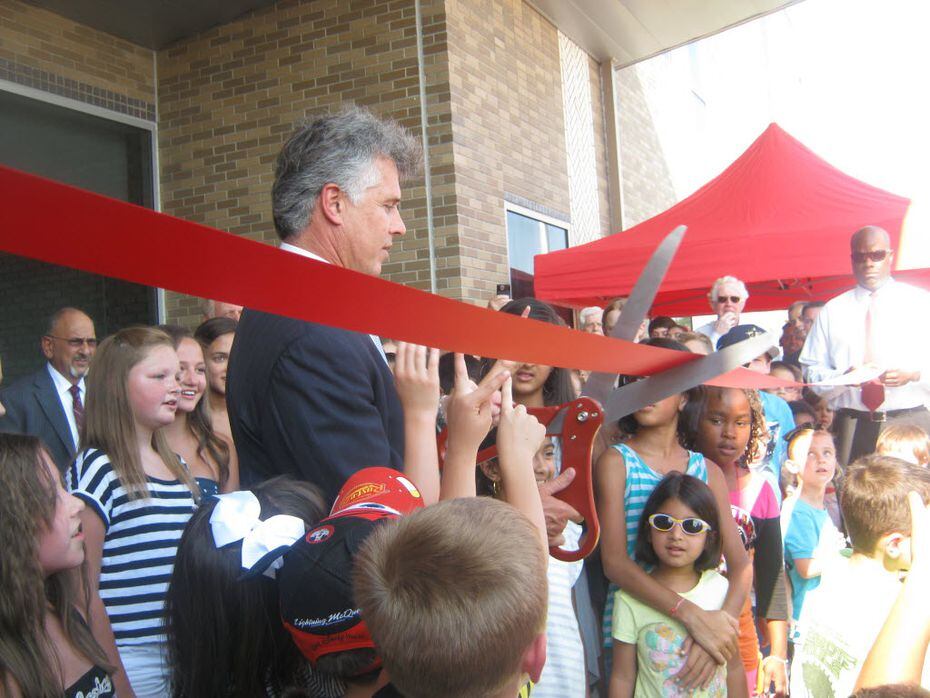 McKinney Mayor Brian Loughmiller, surrounded by future Imagine Academy students, cut the...
