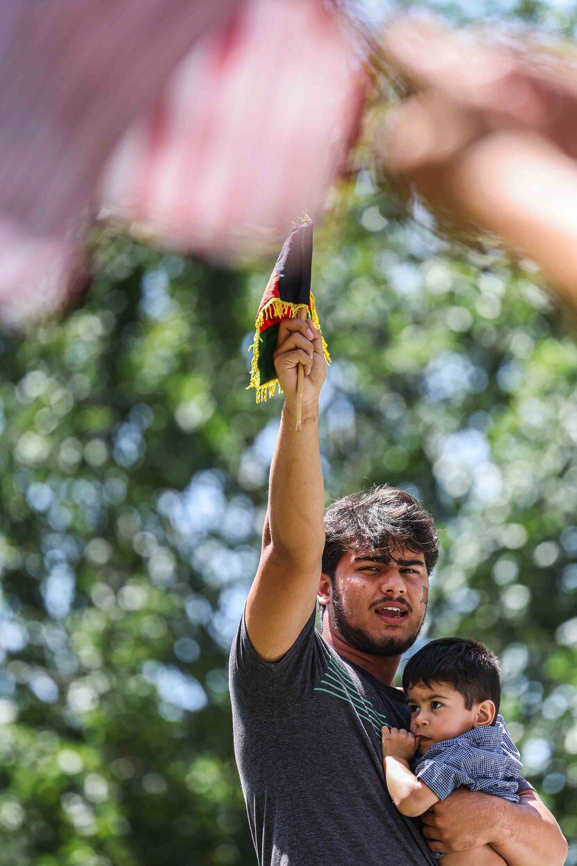 Mohammad Mahbobyar, 19, held his 1-year-old nephew Suvan Yasiney at a rally  in downtown...