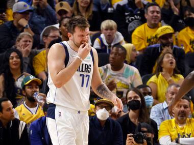 Dallas Mavericks guard Luka Doncic (77) holds his front teeth after being hit in the mouth...