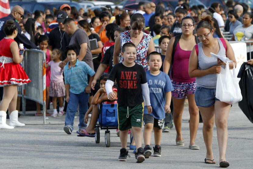 Familias hispanas salen de la Feria de Regreso a Clases de la Alcaldía de Dallas en Fair...