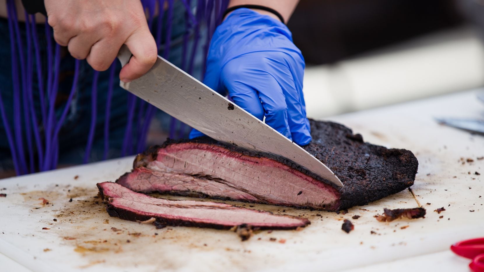 A student slices beef brisket at the State of Texas High School Barbecue Cook-off in Burnet.