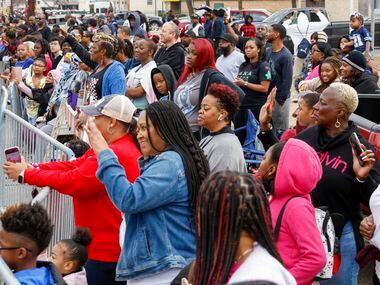 Attendees wave to people during the Martin Luther King Jr. Day Parade in Dallas, Monday,...
