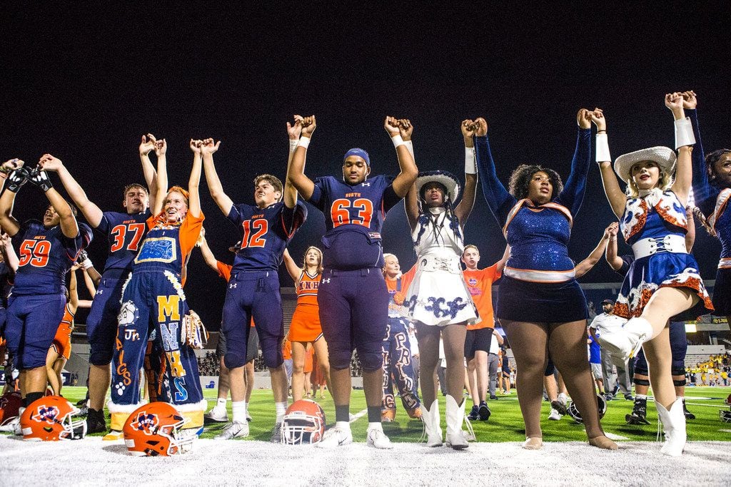 Players and students from McKinney North sing the school song after a high school football...