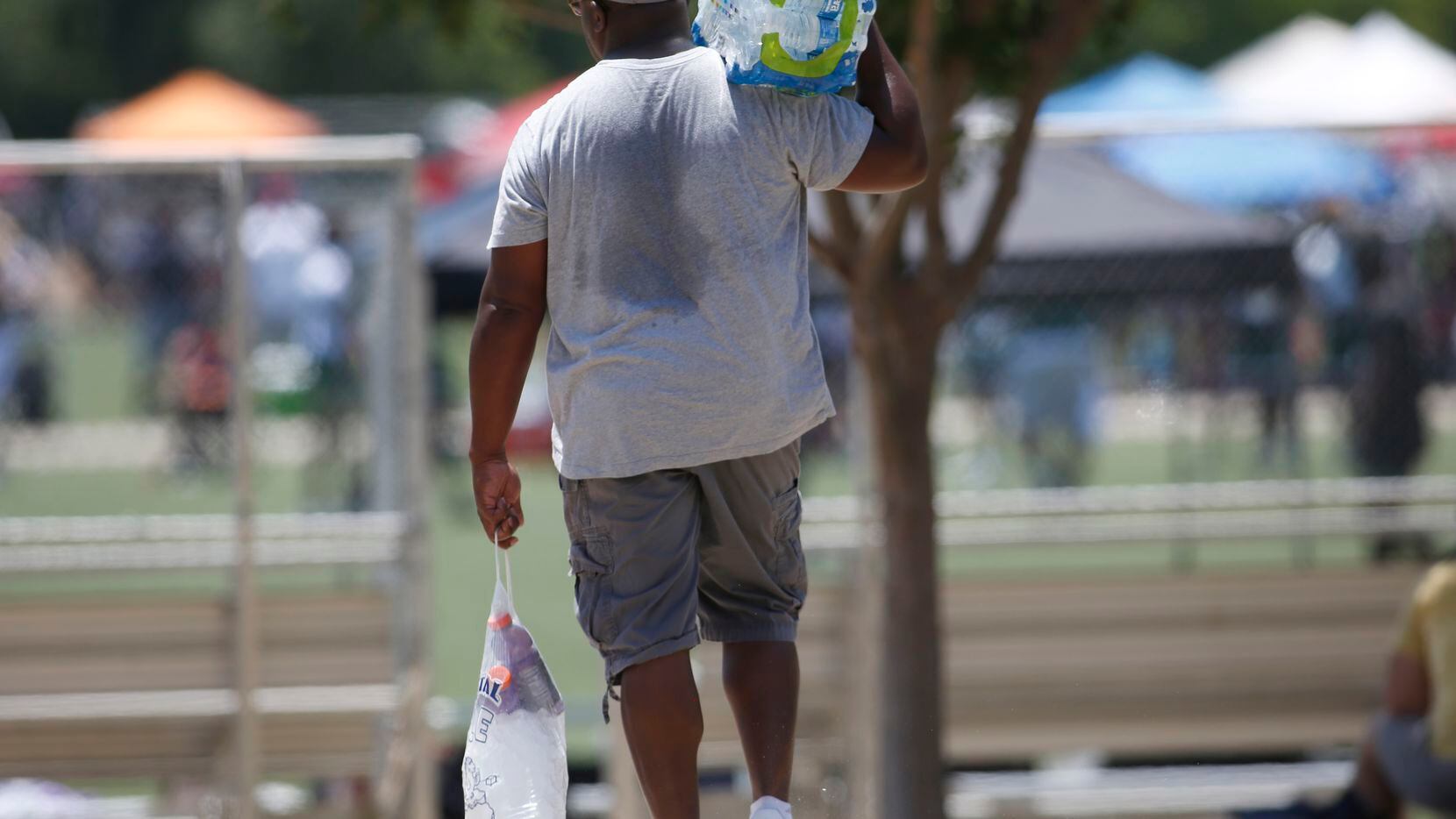 A football enthusiast heads to one of the playing fields with iced drinks and water to help...