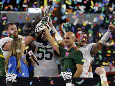 Baylor Bears offensive lineman Connor Galvin (76); linebacker Garmon Randolph (55) and linebacker Terrel Bernard, right, hoist the Championship Trophy with Baylor Bears head coach Dave Aranda, after their 21-16 victory over Oklahoma State in the Big 12 Championship football game at AT&T Stadium in Arlington on Saturday, December 4, 2021. Baylor won 21-16.