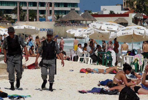 Police patrol the beaches of Cancun, Mexico, during the spring break tourist season.