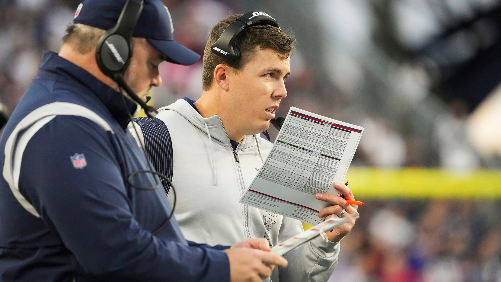 Dallas Cowboys offensive coordinator Kellen Moore works on the sidelines with head coach...