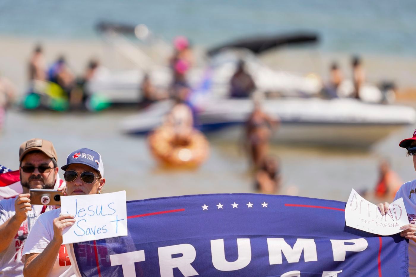 Supporters of President Donald Trump listen as Fabian Cordova Vasquez, candidate for the U.S. House of Representatives 33rd Congressional District, addresses a campaign rally and boat parade at Oak Grove Park on Grapevine Lake on Saturday, Aug. 15, 2020.