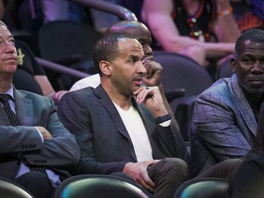 Dallas Mavericks general manager Nico Harrison (center) watches from the stands with Keith...