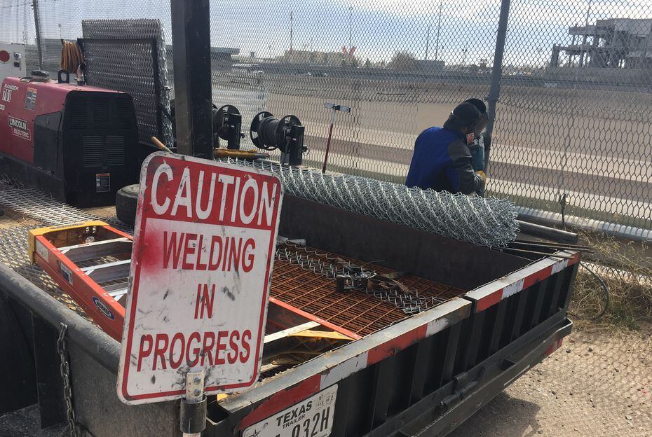 A welding crew repairs holes in the border fence dividing El Paso and Ciudad Juarez almost...