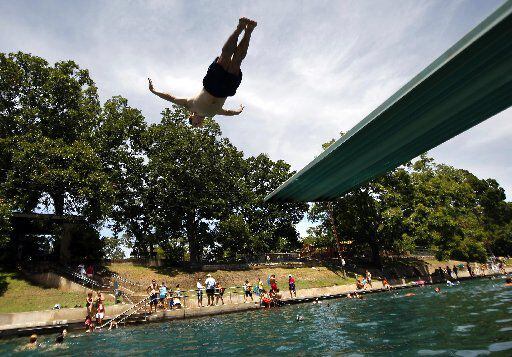 Todd Mouser of Los Angeles California dives at Barton Springs Pool on Friday afternoon...