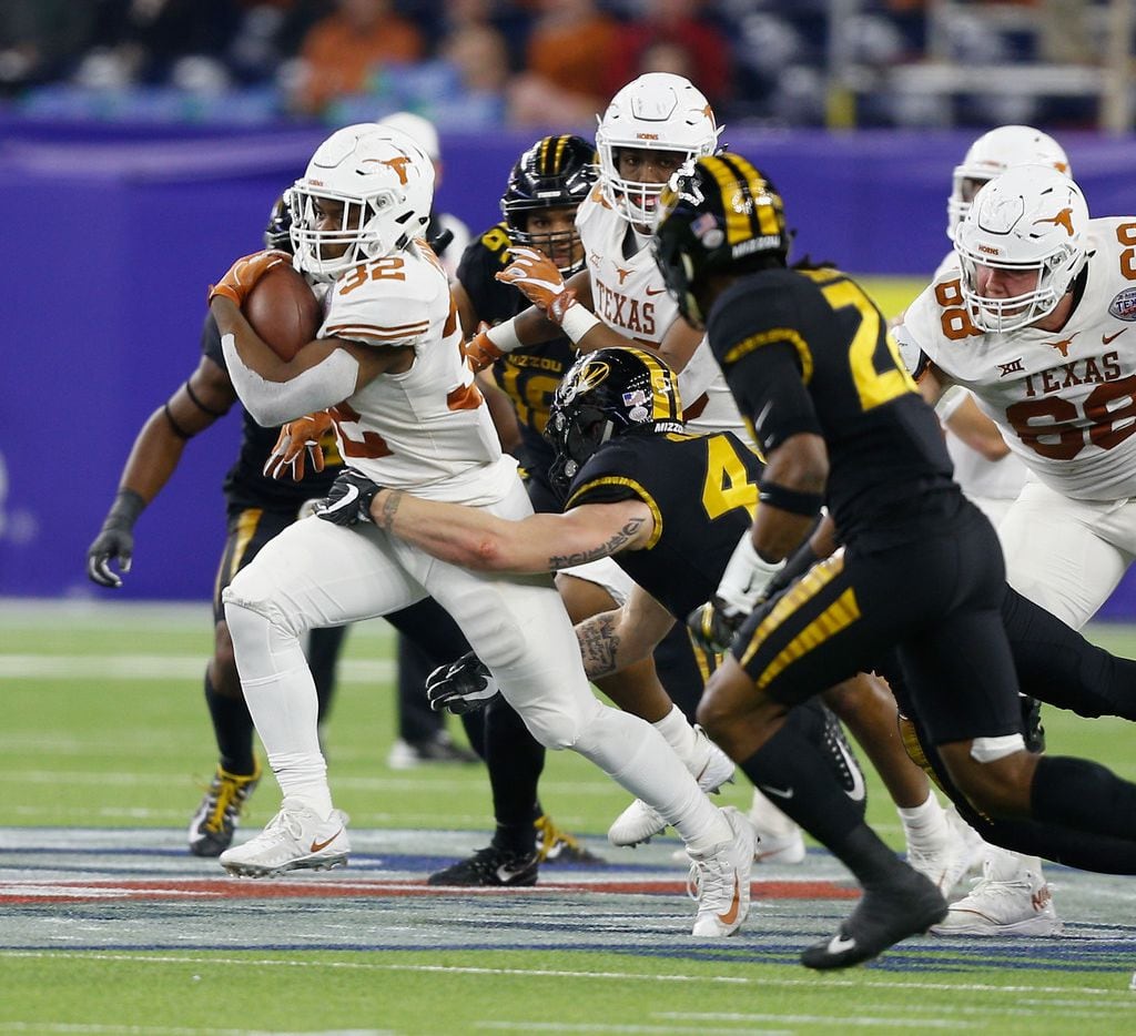 HOUSTON, TX - DECEMBER 27:  Daniel Young #32 of the Texas Longhorns rushes with the balll as Brandon Lee #4 of the Missouri Tigers attempts to tackle at NRG Stadium on December 27, 2017 in Houston, Texas.  (Photo by Bob Levey/Getty Images)