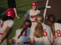 Flower Mound Marcus' Avery Rich is met at home plate by her teammates after hitting a solo...