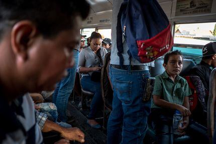 Edgar Yovani Monjel (izq.) y su hijo Cristopher, de 7 años, en Juárez, abordo de un autobús...