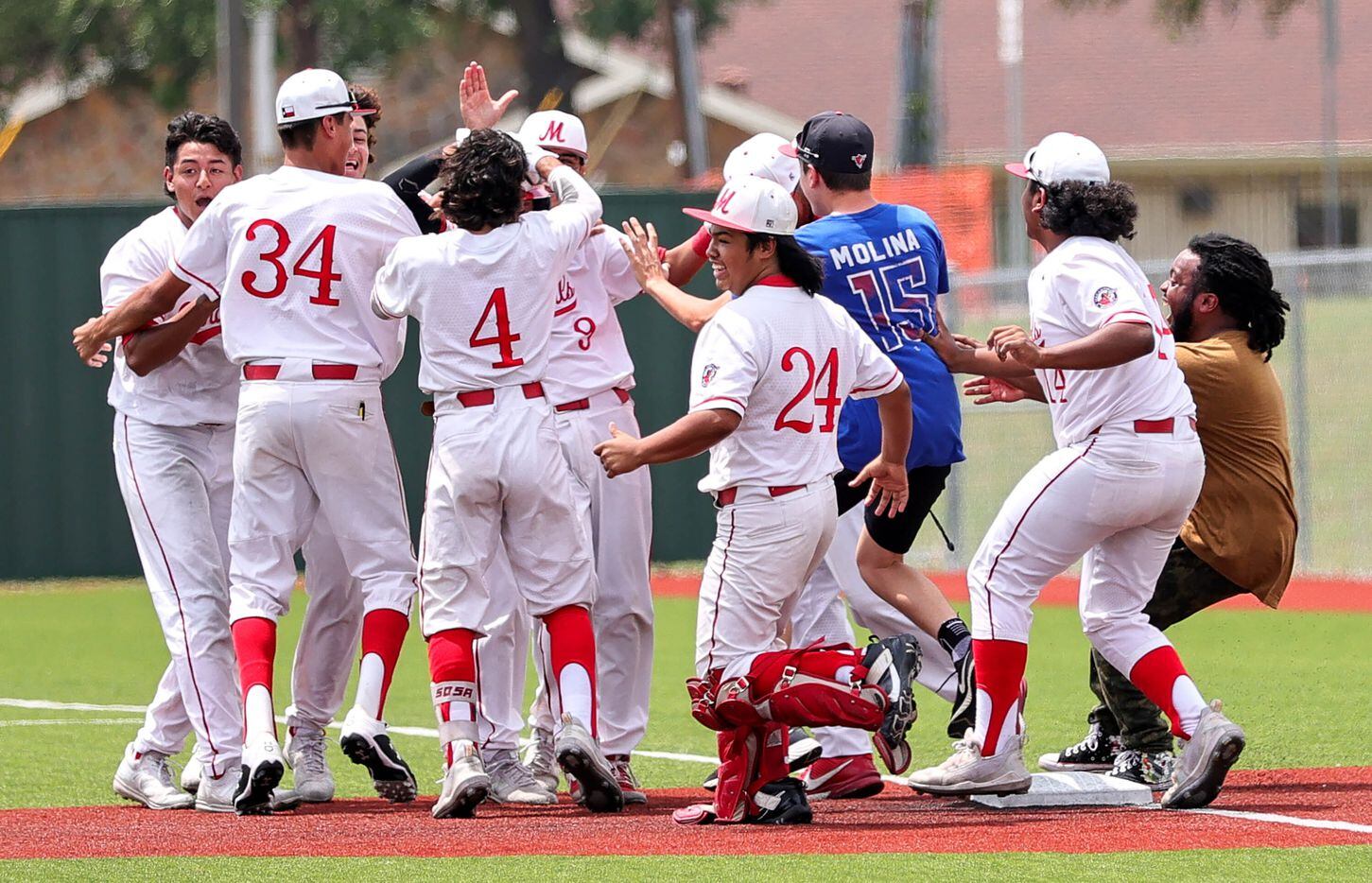 The MacArthur Cardinal celebrate a victory over South Grand Prairie, 5-4 in Game 2 during a...
