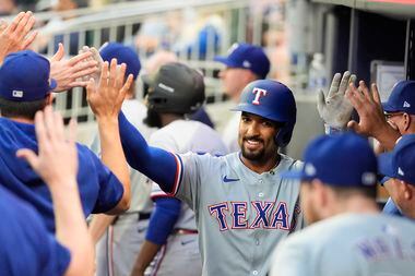 Texas Rangers' Marcus Semien celebrates with teammates in the dugout after hitting a solo...