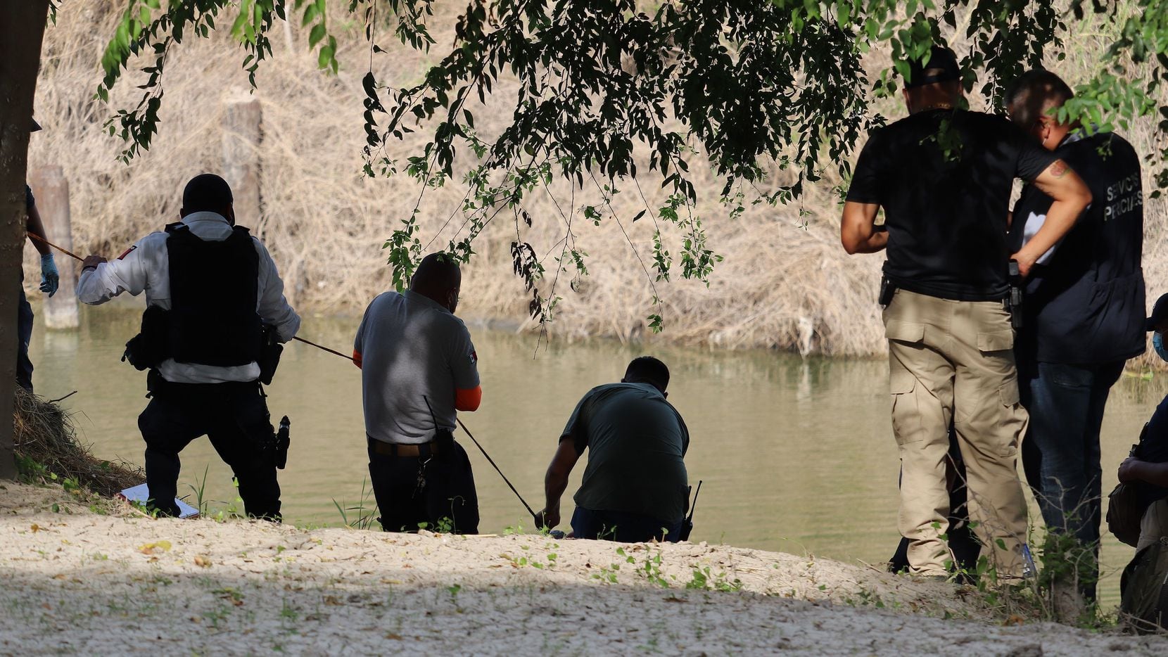 Members of Civil Protection rescue the body of Guatemalan Rodrigo Castro from the Rio Bravo,...