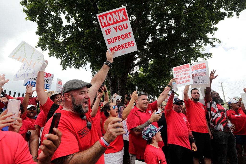 Members of the Communications Workers of America shouted Monday as they walked a picket line...