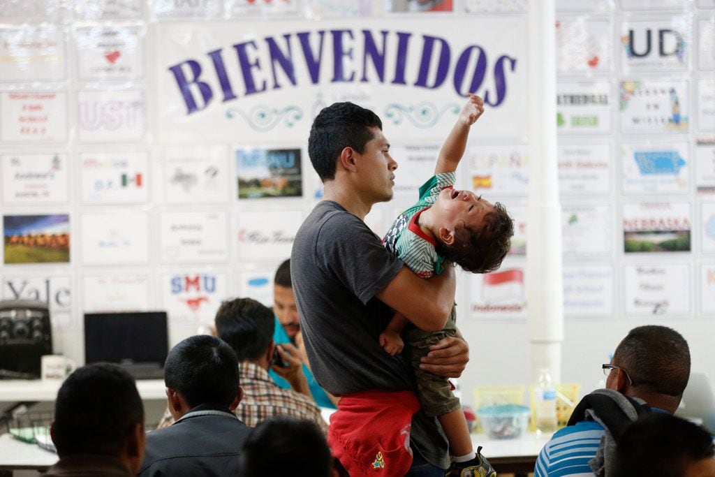 Jonathan Pineda, 23, from El Salvador, holds his son Jonathan Pineda, 2, at the Humanitarian...