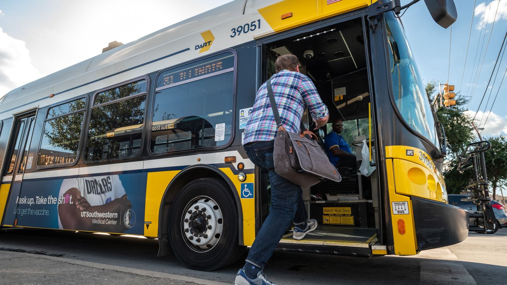 Doyle Rader, a long-time rider of DART, steps onto a bus in August at the intersection of...