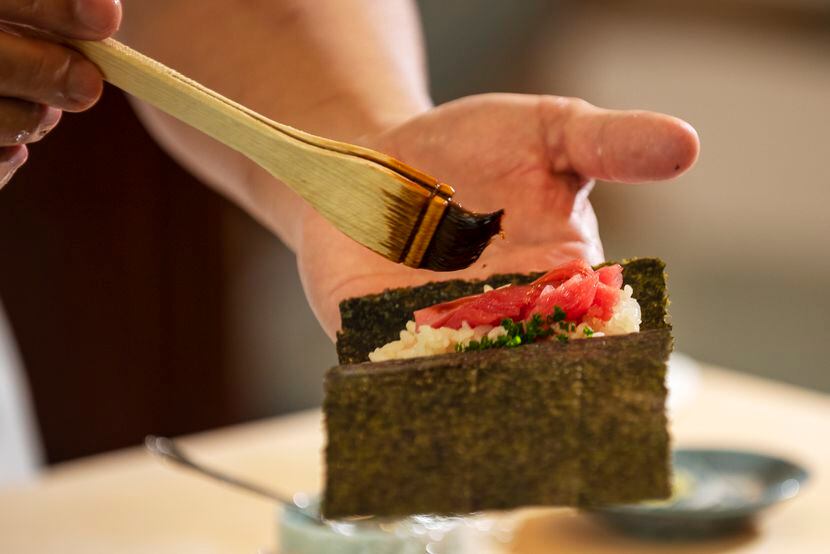 Master sushi chef Tatsuya Sekiguchi prepares a toro hand roll during a private tasting for...