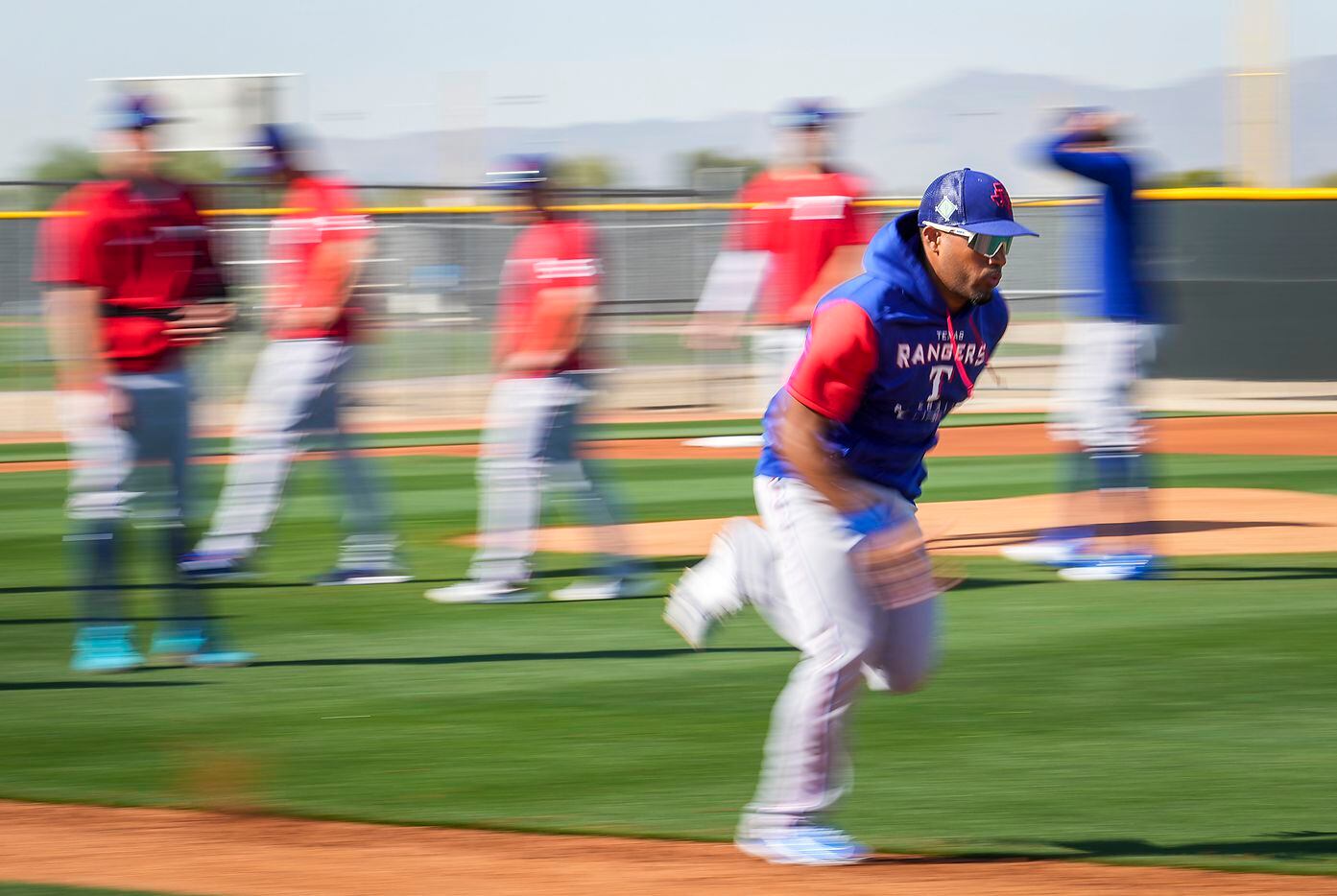 Texas Rangers infielder Andy Ibáñez participates in a base running drill during a spring...