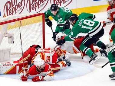 Dallas Stars left wing Michael Raffl (18) stciks the puck past Calgary Flames goaltender...