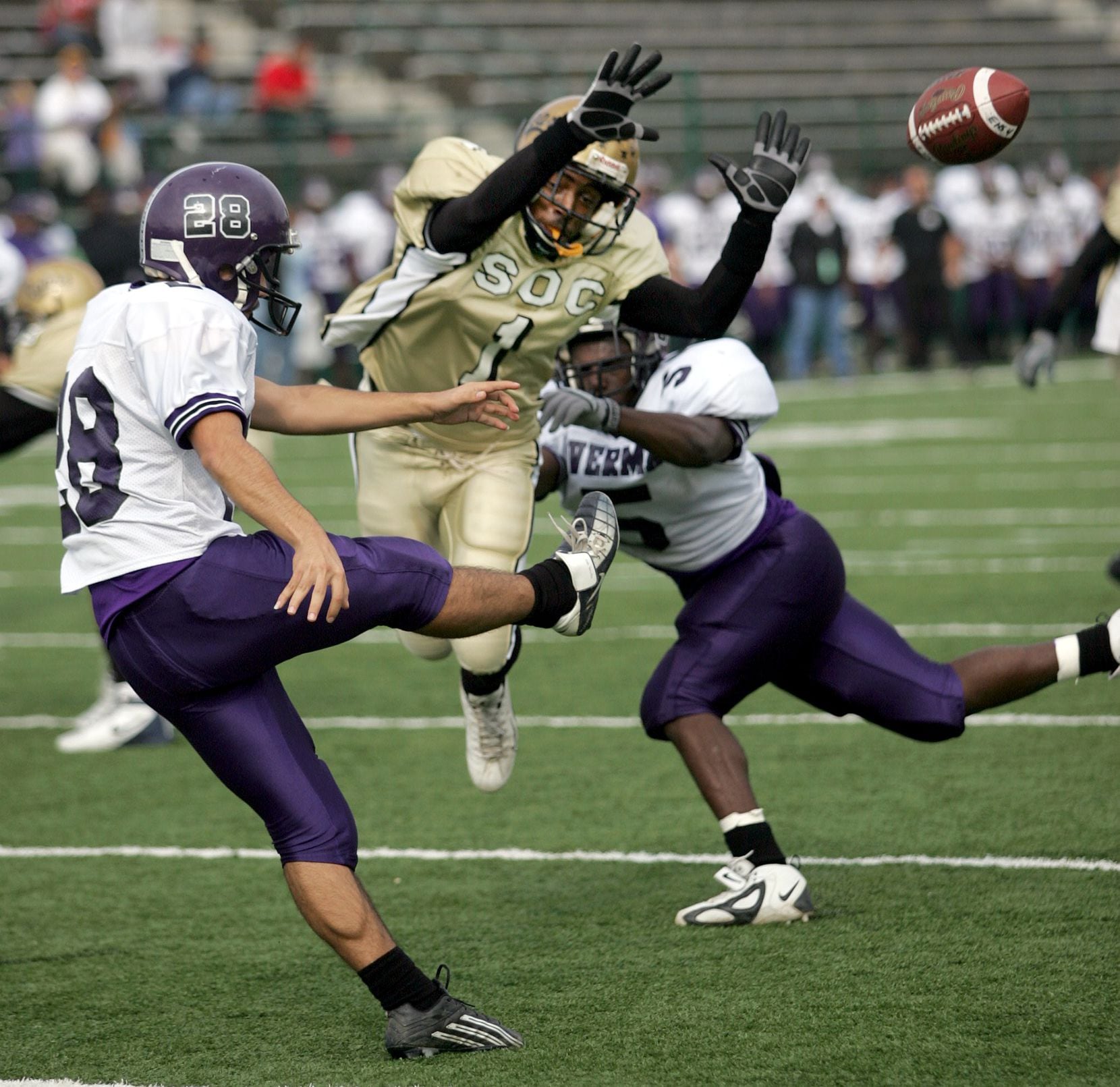 South Oak Cliff's Casey Gerald (center) tries to block a punt  by Everman's Roberto Martinez...