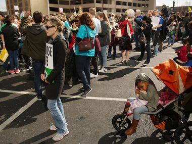 Abigail Burke, 3, of Arlington, Texas, sits in a stroller as anti-abortion activists speak...