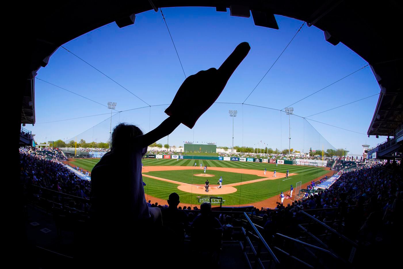 Fans cheer during the fifth inning of a spring training game between the Texas Rangers and...