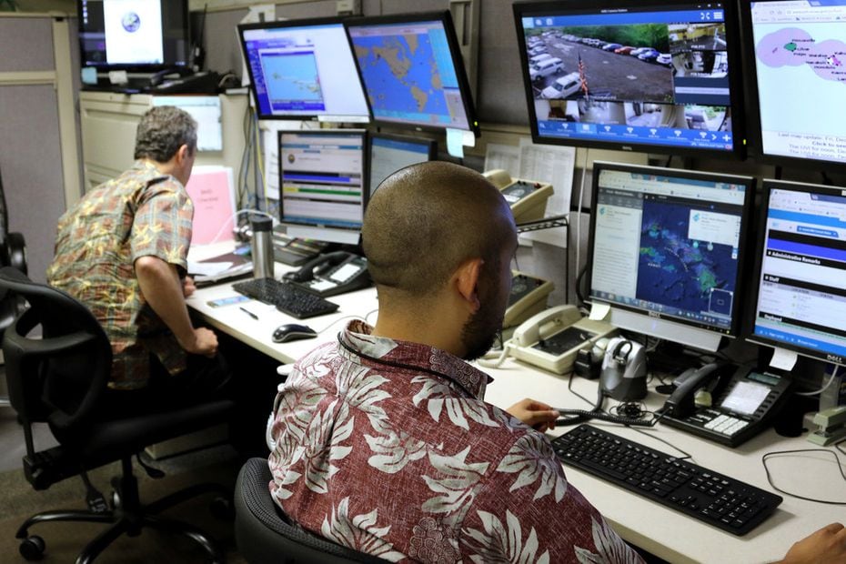 Hawaii Emergency Management Agency officials work at the department's command center in...