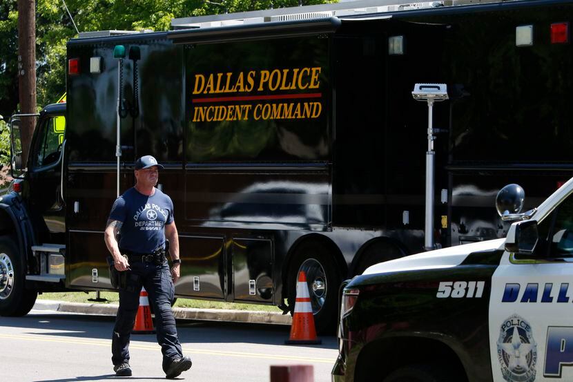 A Dallas SWAT officer walks near the scene of home on Highcrest Drive after a murder-suicide...