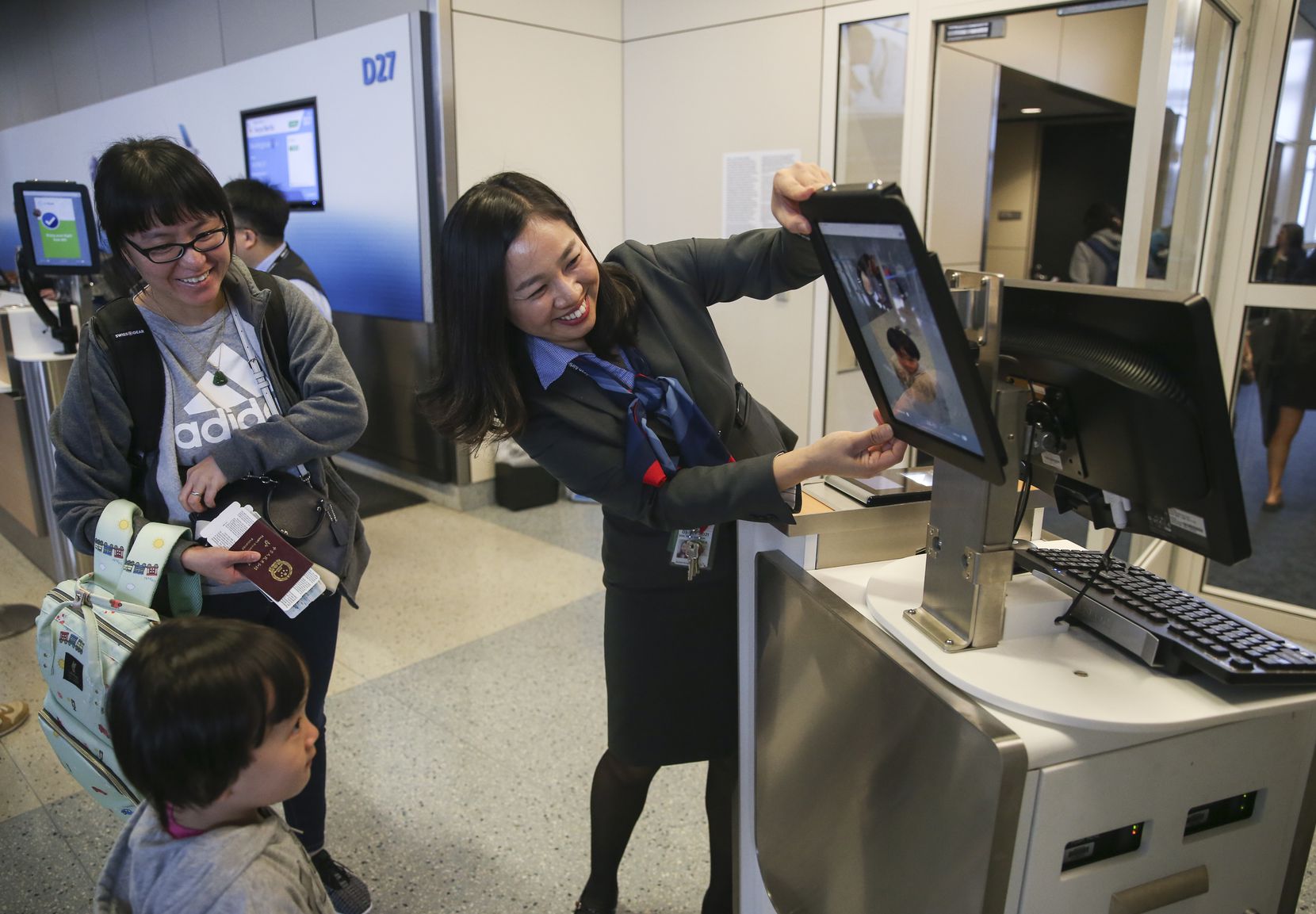 Gate agent Erica Shin assists as passengers board an American Airlines flight to Tokyo...