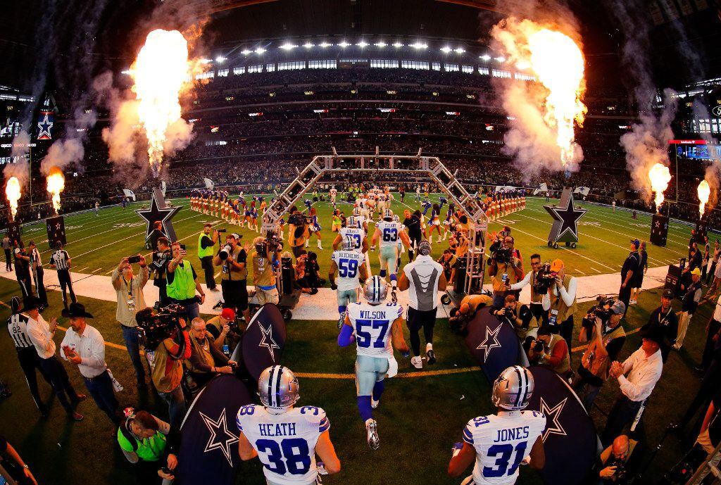 Dallas Cowboys players run onto the field during player introductions before facing the...