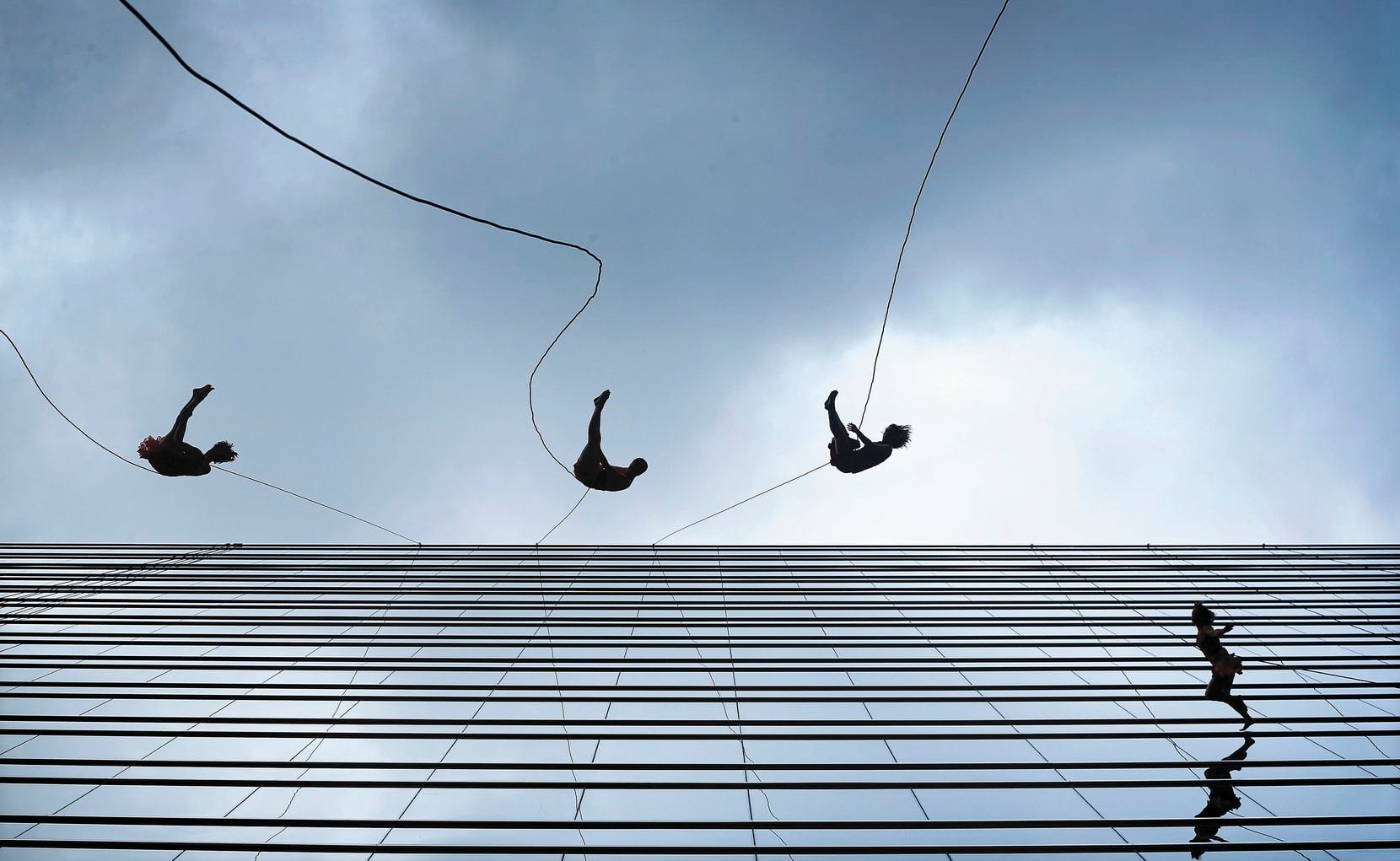 Members of the Bandaloop vertical dance company perform on the side of the KPMG Plaza office tower. The spectacle was part of a groundbreaking ceremony for Hall Arts Hotel and Residences, a 25-story downtown Dallas tower in the Arts District.