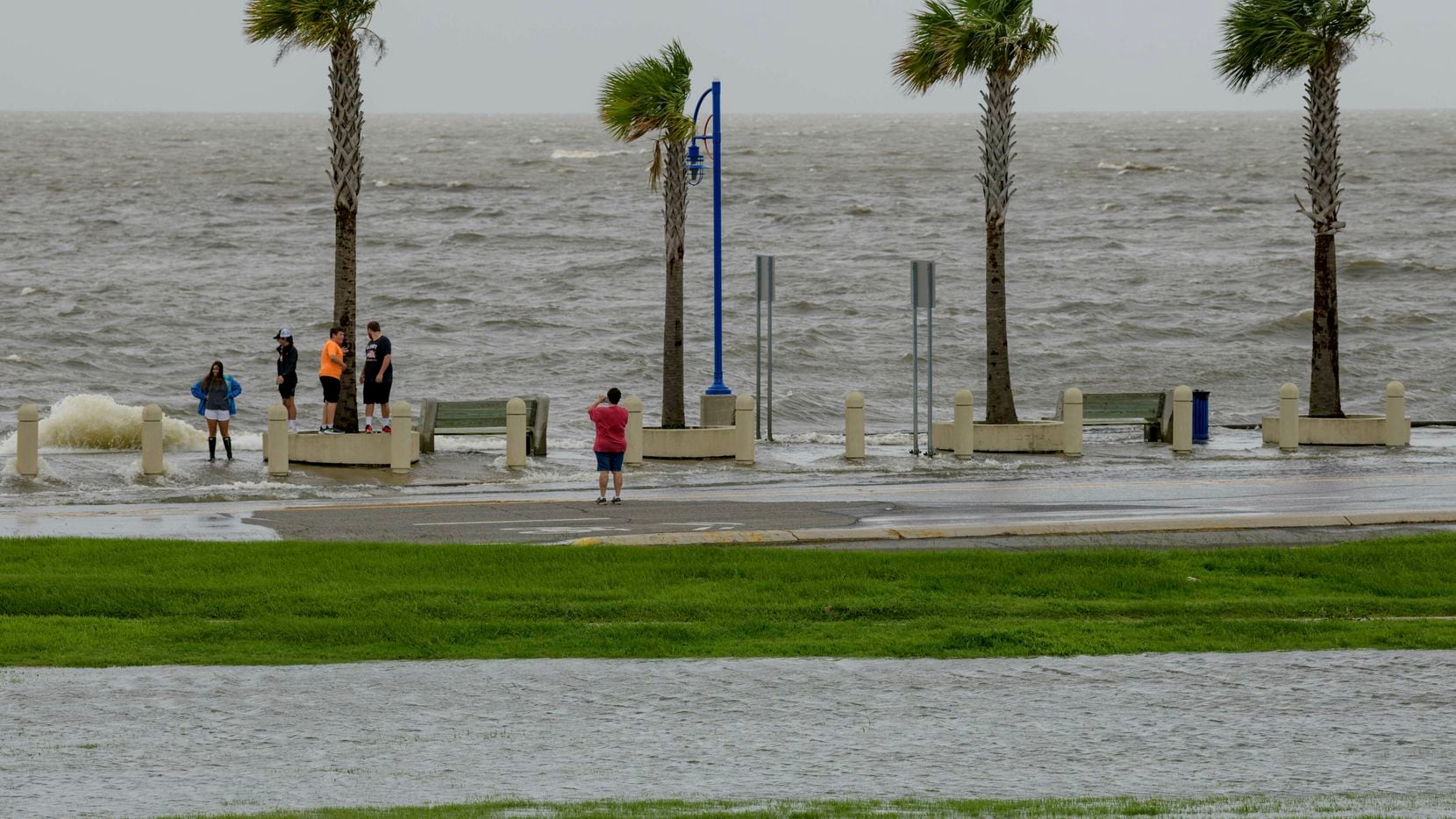 People check out the waves on Lakeshore Drive in New Orleans on Friday as water moves in...