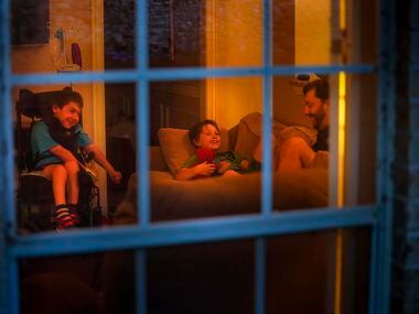 Jeff Carlton reads to his sons Jeffrey, 9, and Scotty, 11, in their living room during the...