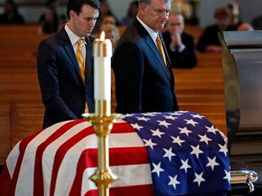 Dallas Mayor Mike Rawlings (right) and his son, Gunnar Rawlings, visit the casket of slain...