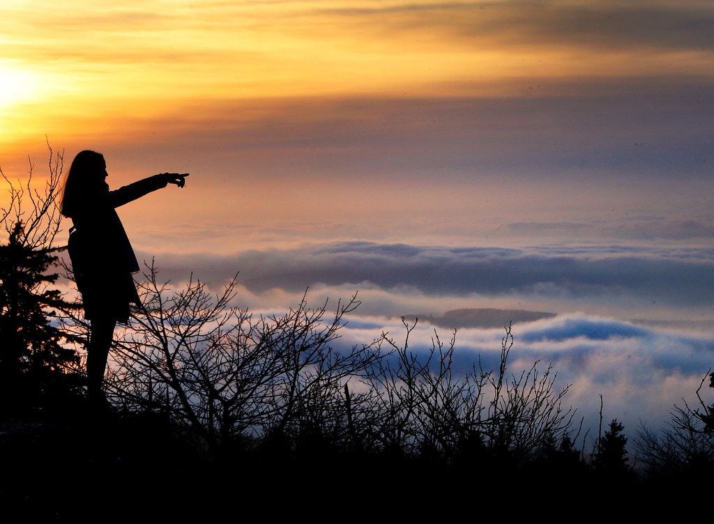 A woman stands on top of the Feldberg mountain as thick fog lies over Frankfurt. (AP...