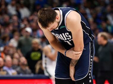Dallas Mavericks guard Luka Doncic (77) grabs his arm after being fouled during the second...
