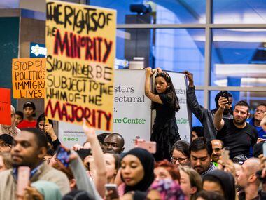 Protestors listen as organizers announce an end to the demonstration at DFW International...