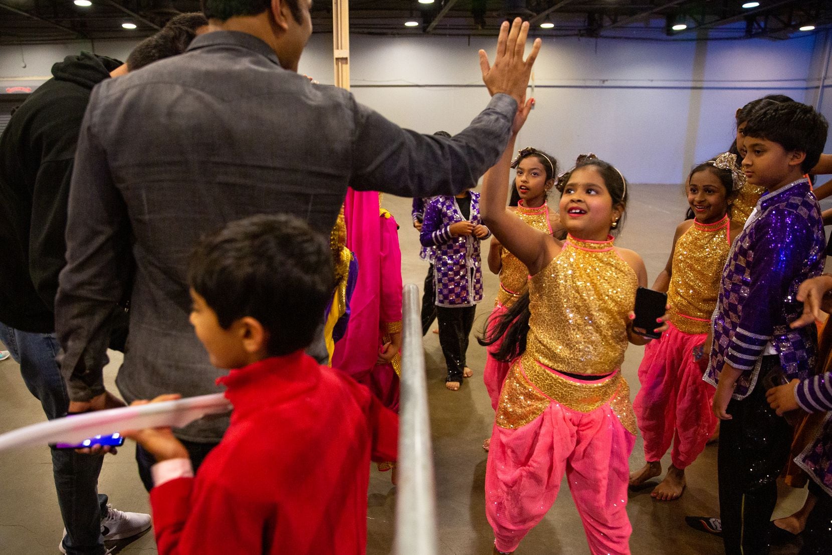 Balayashmitha Allada gets a high-five Saturday after performing with her troupe from Nrithya Dance Academy at Fair Park in Dallas.