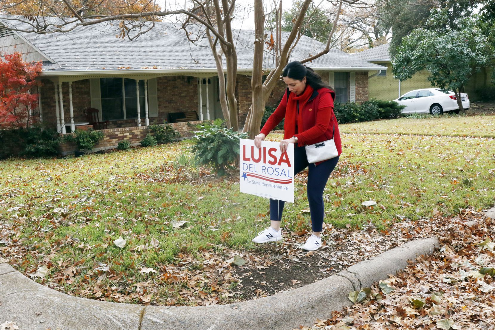 Luisa Del Rosal puts her campaign sign on a supporter's front lawn. She and her campaign manager had a block walk in Texas House District 114 in Dallas on Nov. 23, 2019. Del Rosal is among the Republican candidates looking to take back House districts that Democrats flipped in 2018.