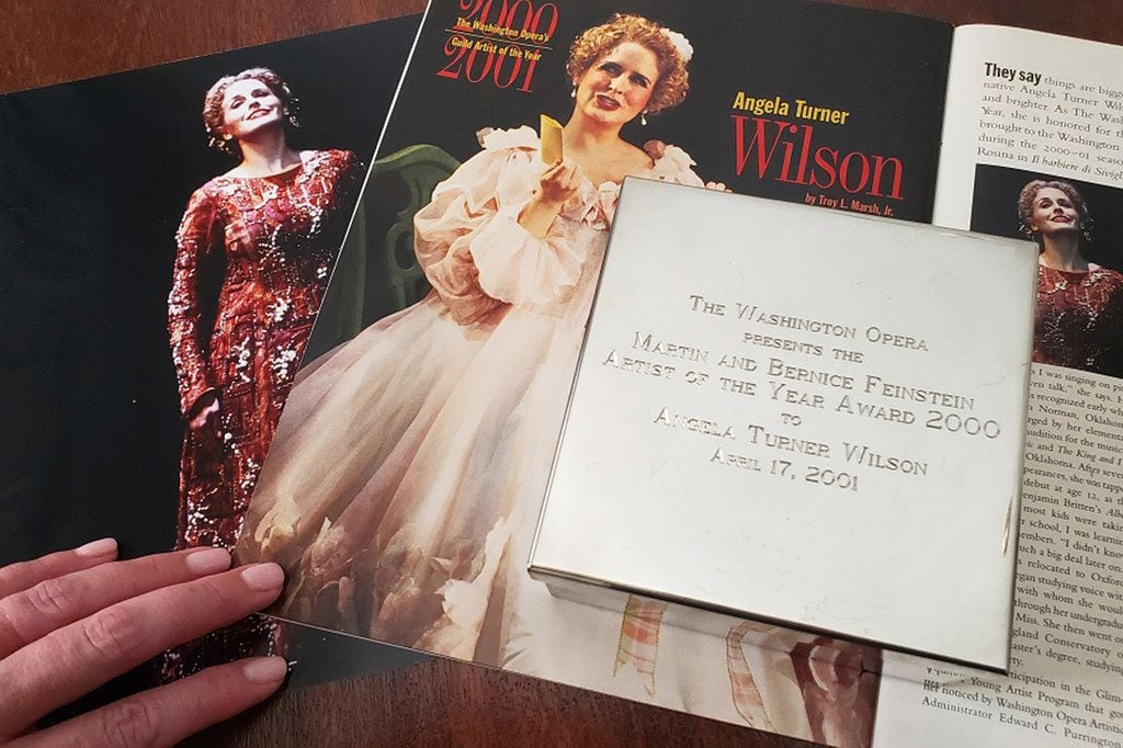 Opera singer Angela Turner Wilson presented her 2000 Artist Award from the Washington Opera, next to a picture of herself drawn from the show The 1999 Cid and a magazine article in a Washington Opera magazine, at her home in Dallas.