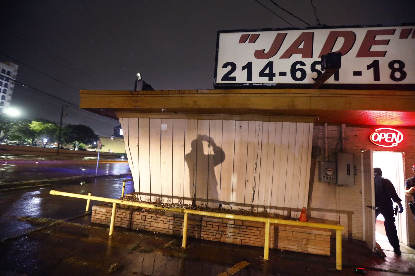 A Dallas Police vice officer takes photos of the outside of Jade Spa, a lucrative massage parlor raided on Market Center Boulevard near the Hilton Anatole Wednesday morning.