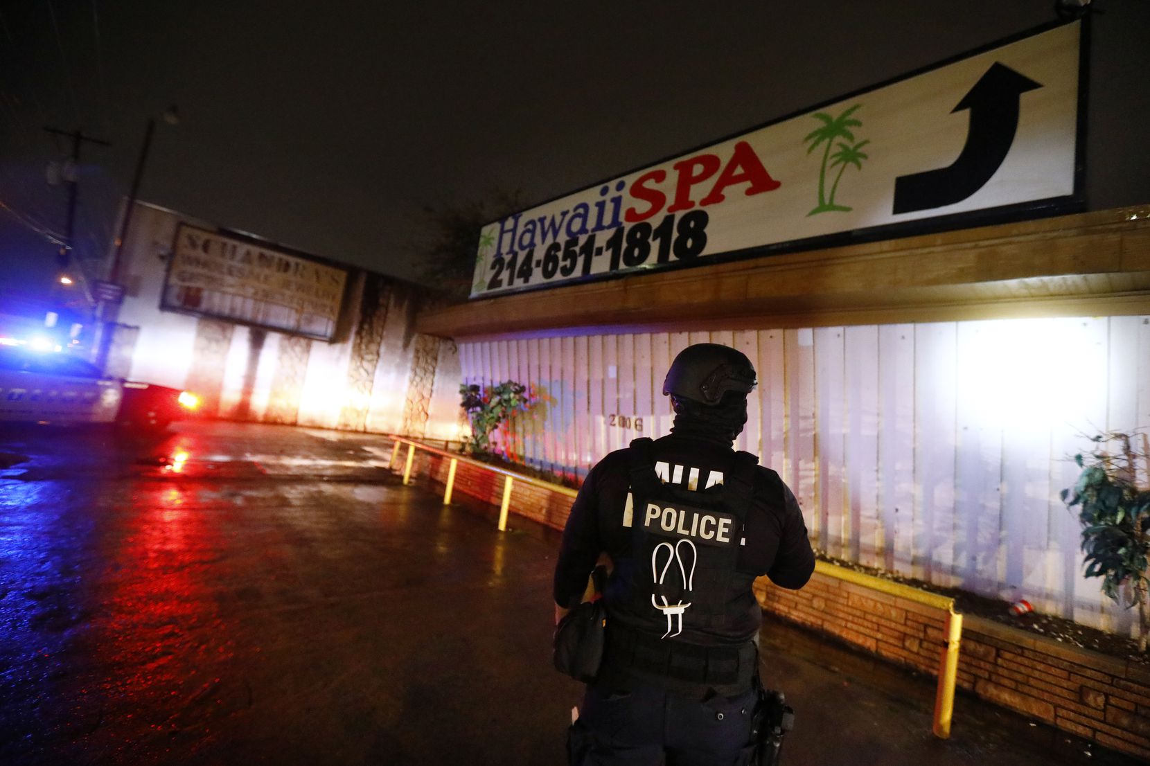 A Dallas Police vice officer inspects the outside of Jade Spa, until last week's raid one of the longest-running illicit massage parlors in Dallas.