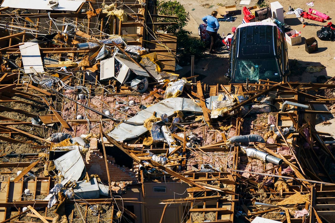 A woman stands in amidst the rubble of a damaged home near Royal Lane and North Central Expressway in an aerial view of tornado damage on Monday, Oct. 21, 2019, in Dallas.